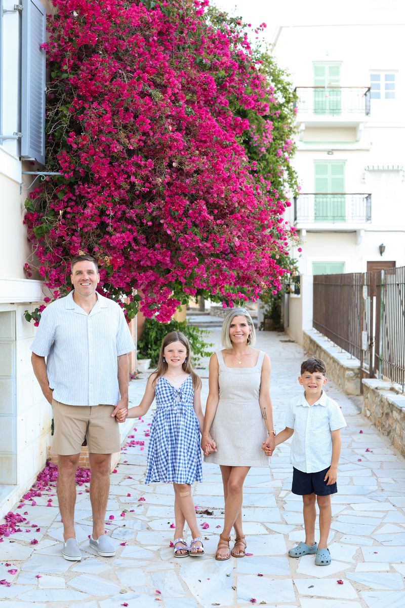 Brendan and his family under pink flowers in Syros, Greece